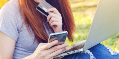 Lady paying on a card using a phone and laptop