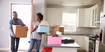 Young couple moving boxes into home