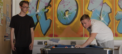 Youth Services - two young adults playing pool